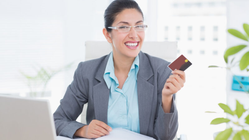 Smiling businesswoman holding her credit card