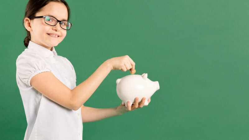 Girl putting coin in piggy bank