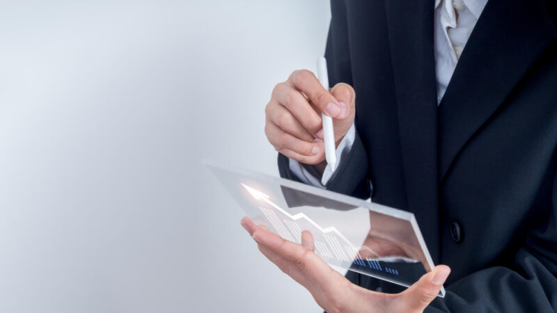 Businessman or trader analyzing financial growth data graph on futuristic digital tablet with copy space concept of investment finance technology stock market trends and modern business strategy