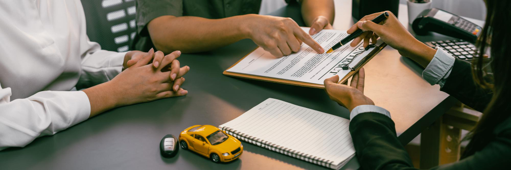 Car dealer calculate interest rate and costs of car loan offering financial and insurance service while customer client reading on term and agreement on contract in dealership office prodigy
