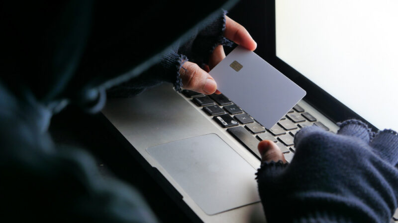 Hacker hand stealing data from credit card