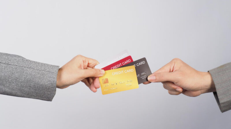 Hands are sent and receive credit cards on white background