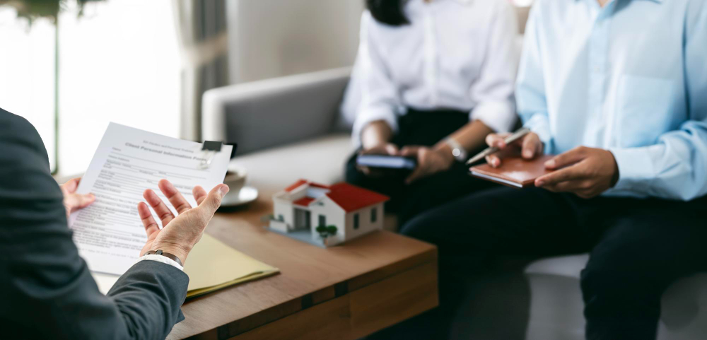 Real estate agent having a discussion with his client about purchasing house and signing contact
