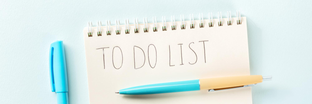 To do list panorama a paper notebook with a pen shot from above
