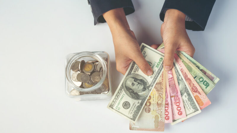 Woman employees counting money on a white desk