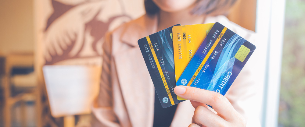 Women hold three credit cards.Ards.For web banner.
