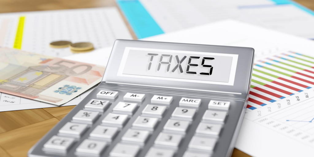 Taxes word on calculator display euro money and business reports on office desk
