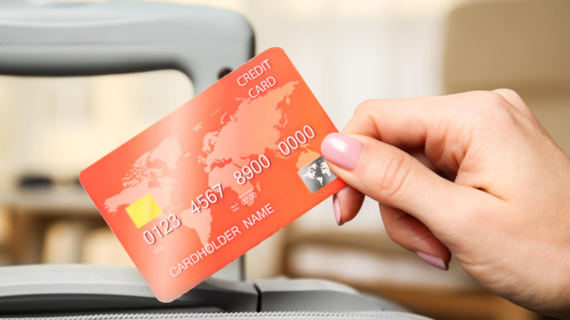 Female hand holding credit card on blurred background