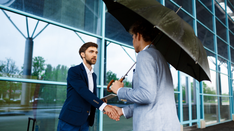 Picture of two young businessmen meeting at station