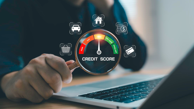 Businessman analyzing credit score on laptop with magnifying glass and digital gauge showing good to excellent rating financial risk assessment of personal finance and loan approval concept